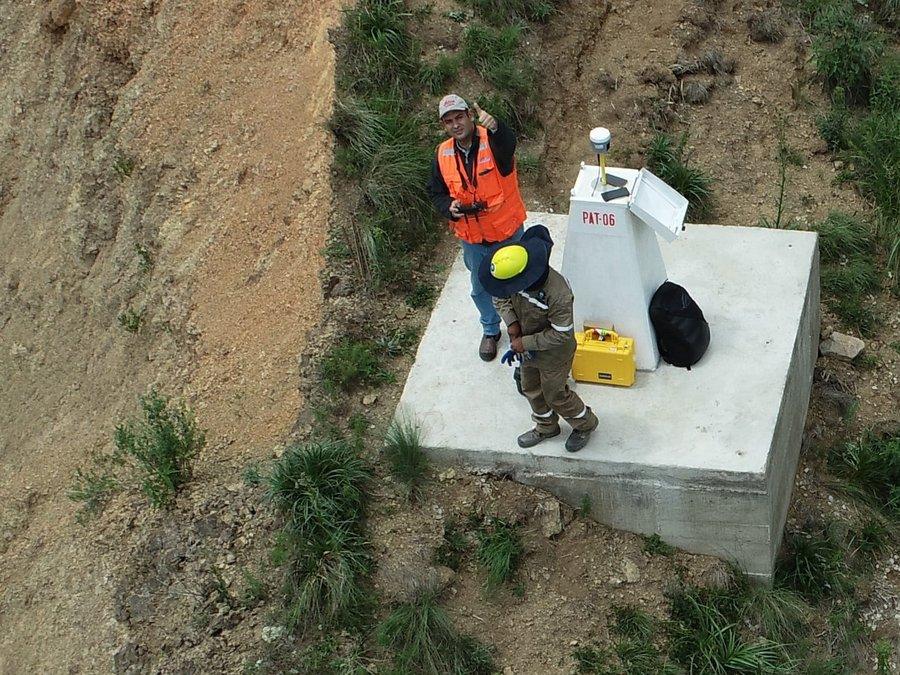 Equipo de levantamiento junto al monumento geodésico PAT-06, con la base GNSS instalada, en la ladera de la tubería de aducción Misicuni, Cochabamba