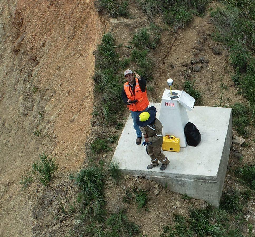 Vista aérea del equipo de levantamiento junto al monumento geodésico PAT-06 con la base GNSS instalada, en la ladera de la tubería Misicuni